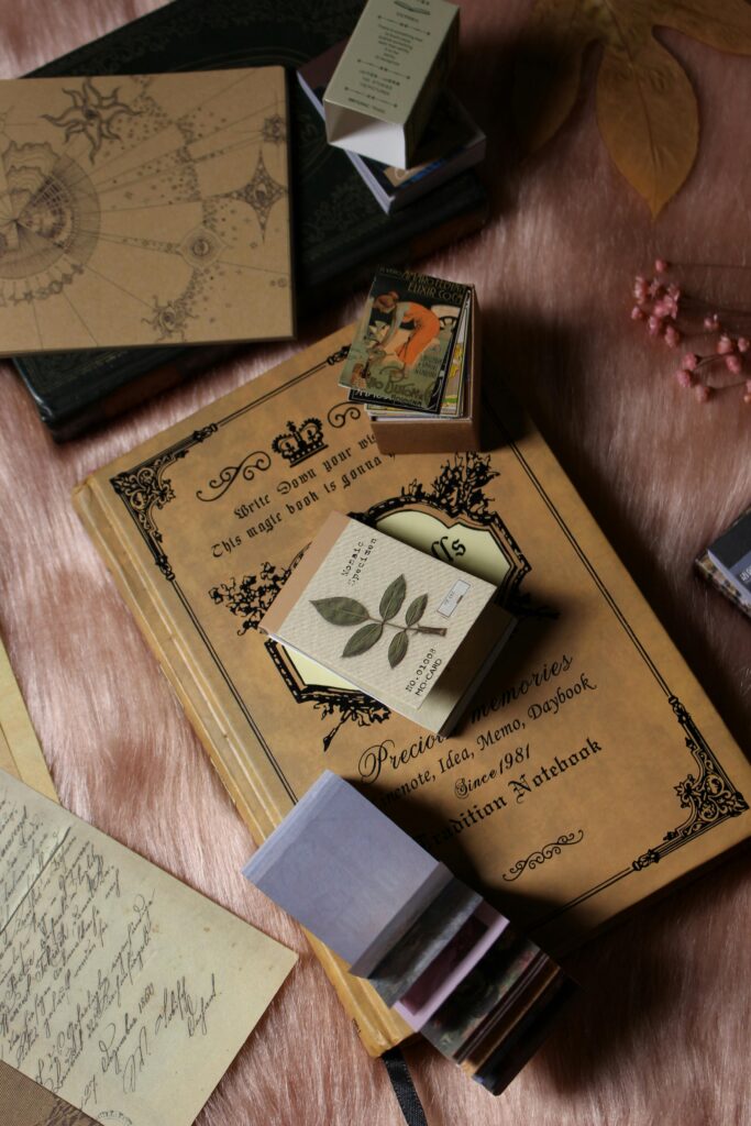 Aesthetic vintage journals on a textured tabletop with artistic elements.