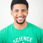 Portrait of a smiling young man wearing a green T-shirt with science text.